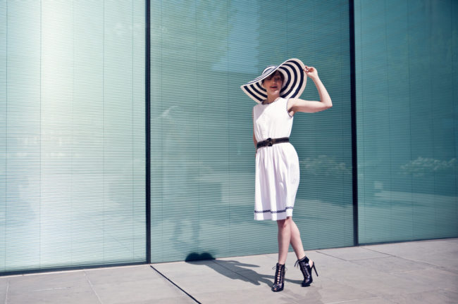 very elegant girl wearing white dress and a very wide hat