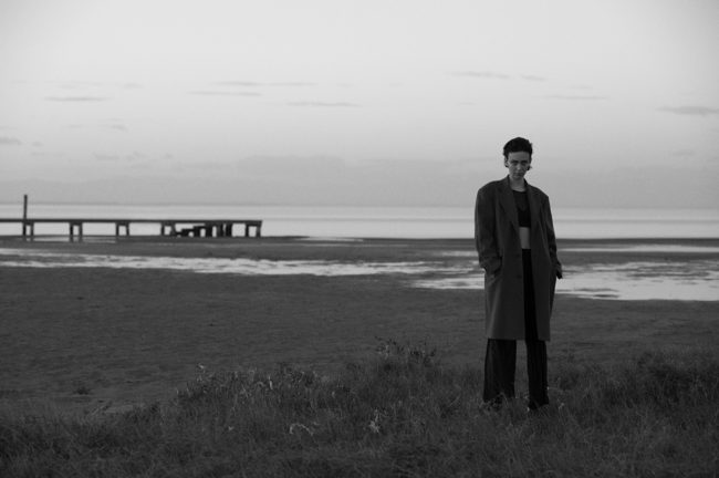 black and white photo of a model on the beach