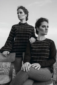 twin sisters with checked shirts looking at the horizon