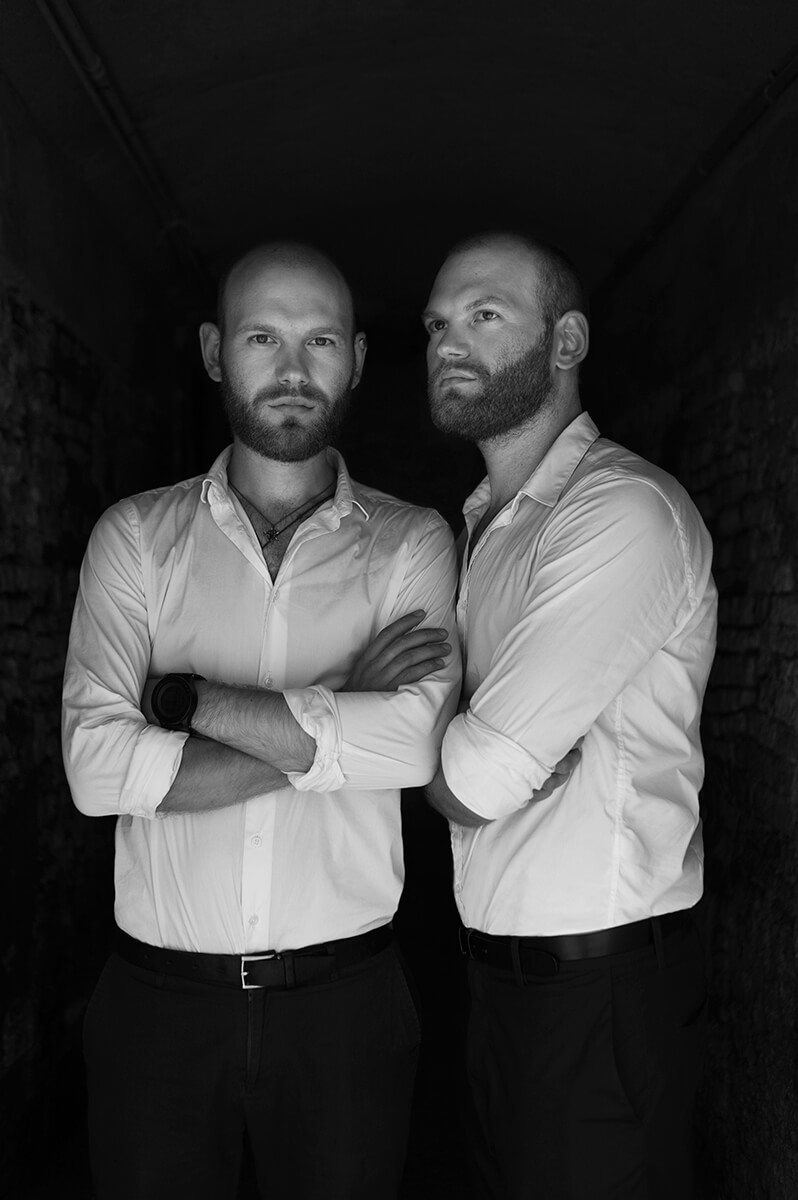 black and white photo with twin brothers in white shirts and black pants
